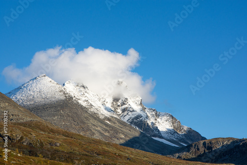 Montain scenery with snow on the peaks against blue  sky