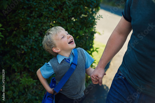 Father and son walking to school together photo