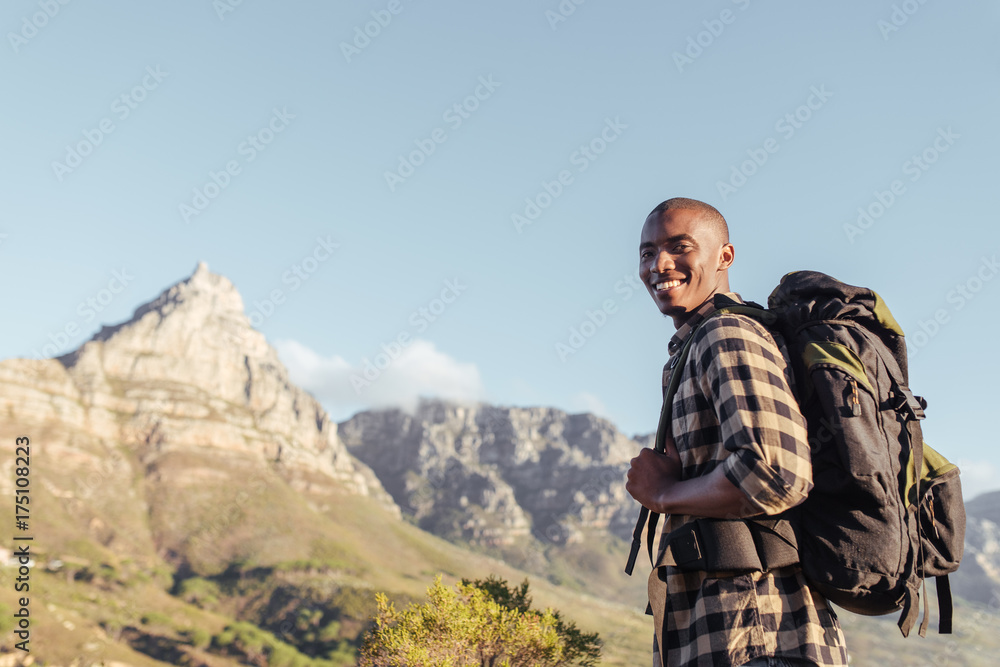 Smiling young African man enjoying the view while out hiking