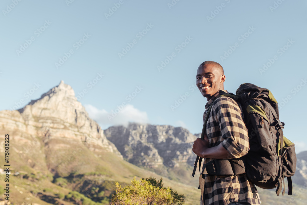 Smiling young African man enjoying the view while out hiking Smiling young African man enjoying the view while out hiking