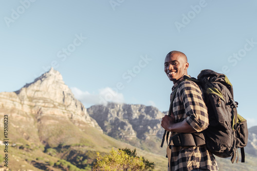 Smiling young African man enjoying the view while out hiking