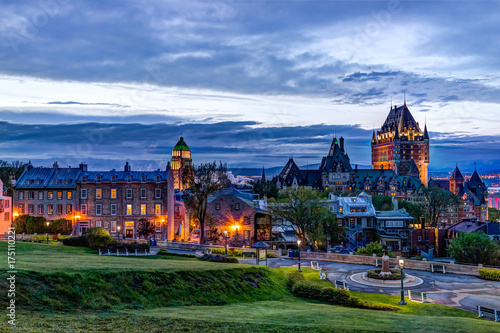 Cityscape or skyline of Chateau Frontenac, park and old town streets during sunset with illuminated castle and Saint Denis street buildings
