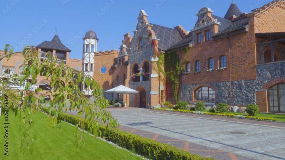 A cozy patio. Cozy European Sunny courtyard. The building with the arch. Beautiful garden. A large blue clock on the wall of the building. Residence of kings. Kaliningrad Russia. A cozy patio. Cozy European Sunny courtyard. The building with the arch. Beautiful garden. A large blue clock on the wall of the building. Residence of kings. Kaliningrad Russia.