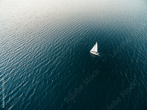 Aerial drone image of a sailboat sailing into sunset photo
