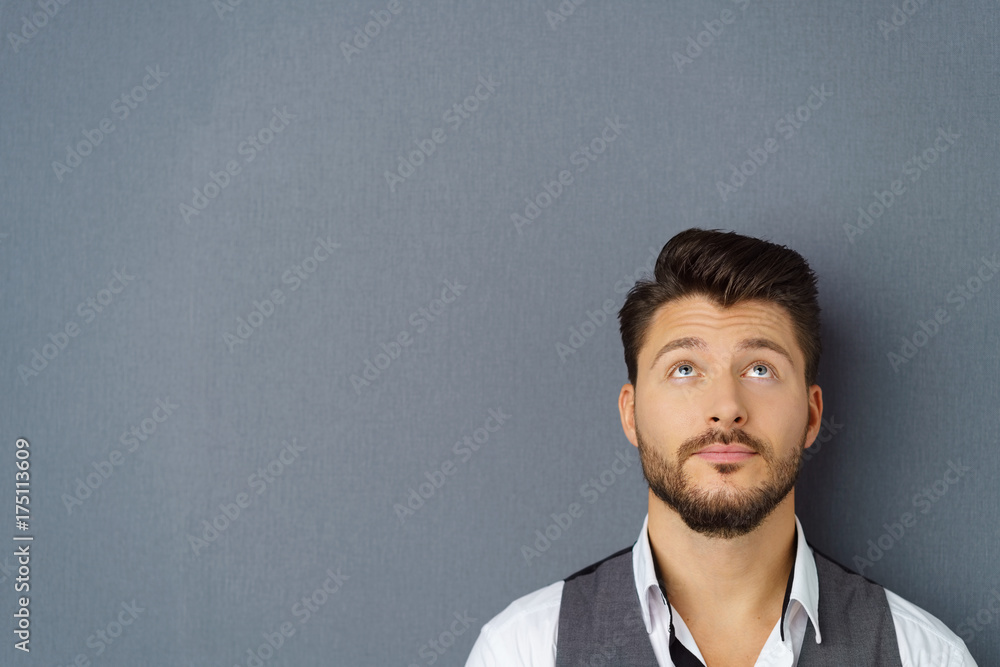 mann schaut mit ernstem gesichtsausdruck nach oben Stock-Foto | Adobe Stock