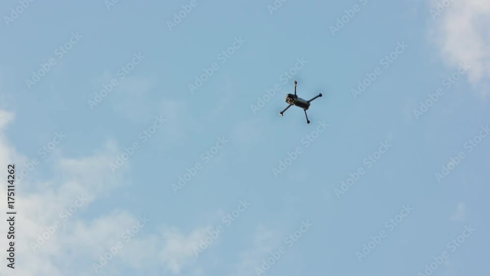 Flying drone with blue sky background, steady in air, then moves away from frame. Medium. Outdoors. Sunny. Stabilized. No people Flying drone with blue sky background, steady in air, then moves away from frame. Medium. Outdoors. Sunny. Stabilized. No people