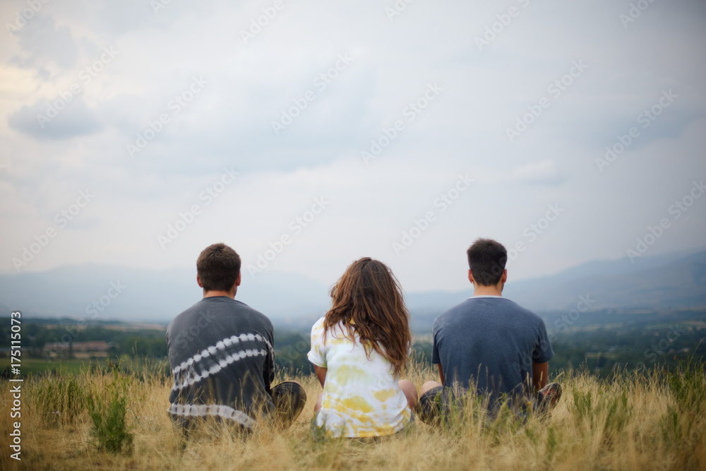 Teenagers sitting on the grass and contemplating Teenagers sitting on the grass and contemplating