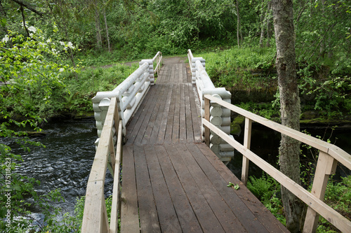 Wooden bridge across the river in the forest © arbalest