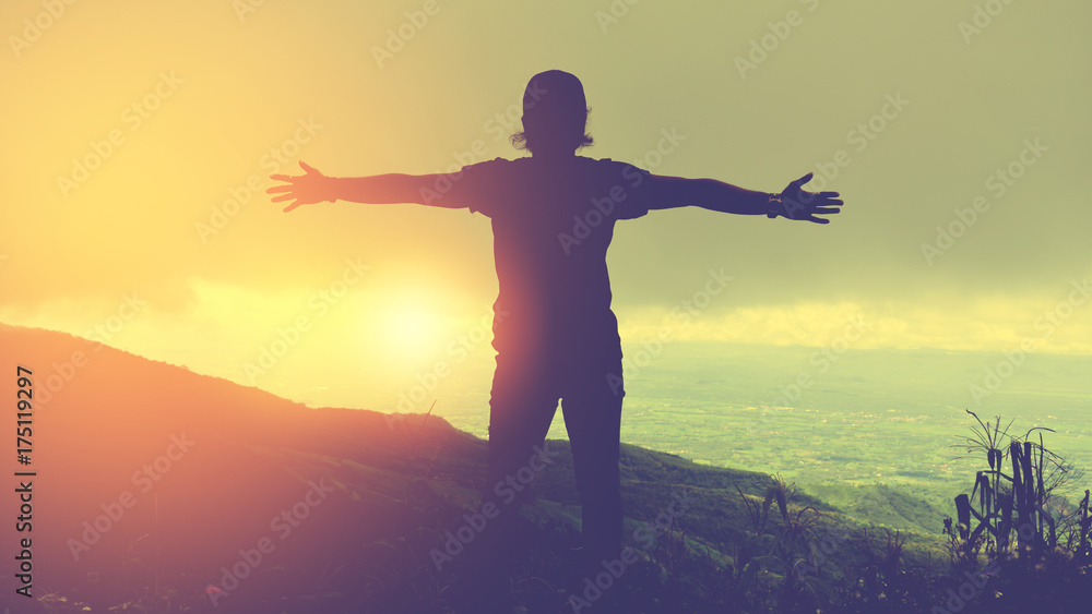 Asian man travel relax in the holiday.Standing hands on cliffs on the mountain.