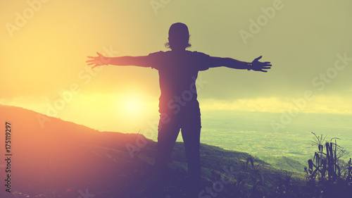 Asian man travel relax in the holiday.Standing hands on cliffs on the mountain.