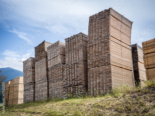 View wood planks stacked in huge piles in sawmill factory. 