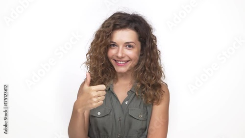 charming long curly haired girl happily showing thumb up isolated on white background. Concept of emotions photo