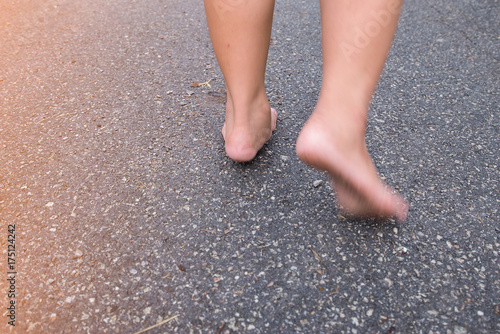 Two feet walking on the street. With barefoot