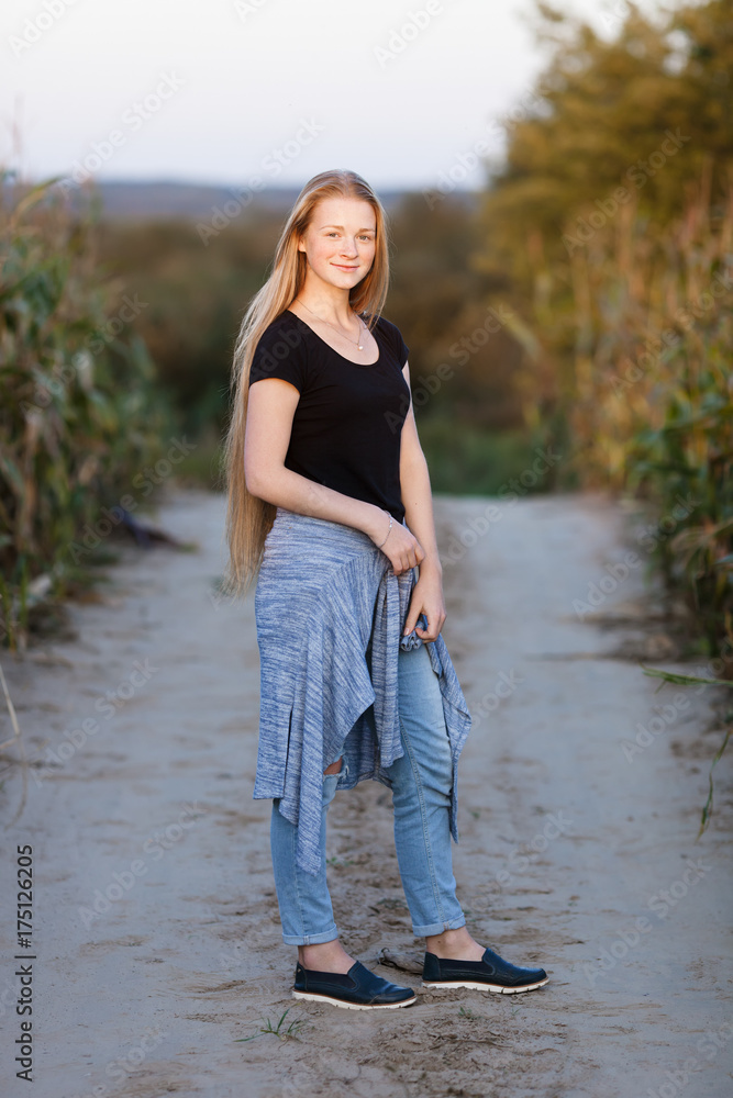 Outdoors lifestyle portrait of young adorable fresh looking redhead woman with freckles gorgeous extra long hair corn field sunny evening. Emotion and facial expression concept. Outdoors lifestyle portrait of young adorable fresh looking redhead woman with freckles gorgeous extra long hair corn field sunny evening. Emotion and facial expression concept.