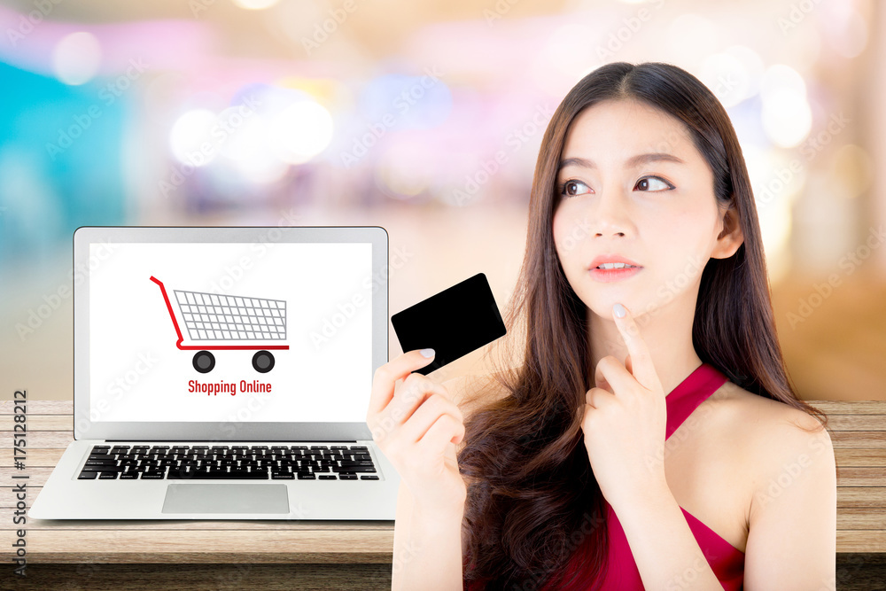 Beautiful woman asia using credit card shopping online with labtop, notebook on table top and bokeh background, girl thinking payment with computer. Beautiful woman asia using credit card shopping online with labtop, notebook on table top and bokeh background, girl thinking payment with computer.