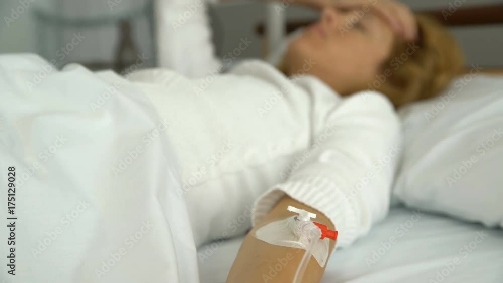 A young female patient in a hospital ward with a drip A young female patient in a hospital ward with a drip