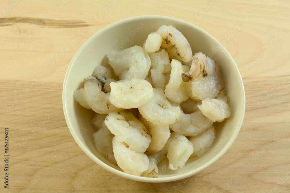Raw peeled fresh shrimp in white bowl in preparation for cooking dinner Raw peeled fresh shrimp in white bowl in preparation for cooking dinner