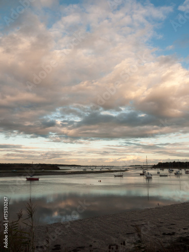 boat moored in estuary stream river dramatic sky autumn sunset country