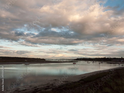 boat moored in estuary stream river dramatic sky autumn sunset country