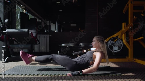 Woman athlete doing crunch exercise on the mat in the gym