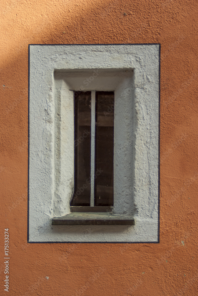 kleines schmales Fenster in einem alten restaurierten Gebäude mit neu gestrichener Fassade, small narrow window in an old restored building with new painted façade