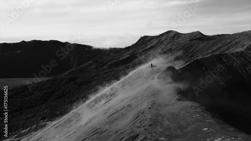 A man going in a fog along the cratrer of volcano Bromo
