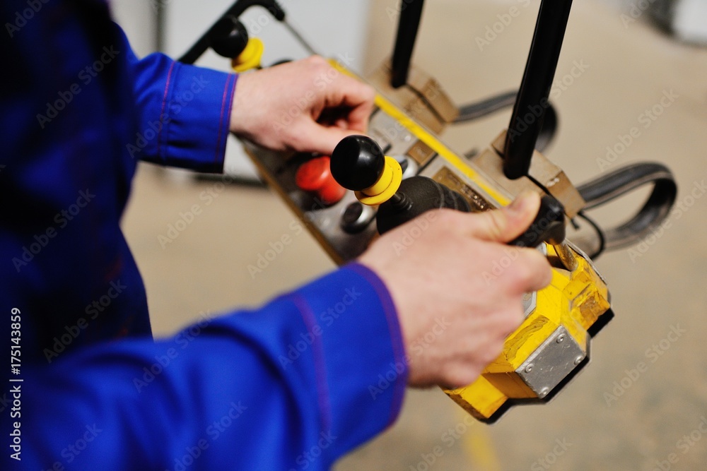 Man, factory, remote control in the hands of a production background Man, factory, remote control in the hands of a production background