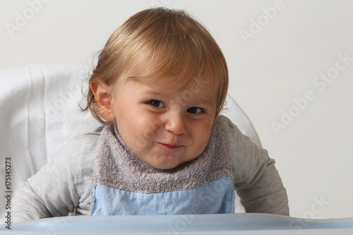 Foto blond child smiling with a lot of malice