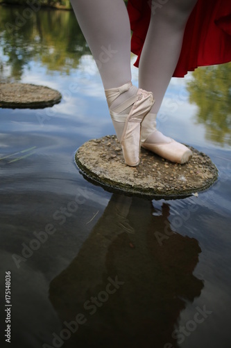 Ballerina with Pointe Shoes Standing in a Pond with Trees in the Reflection of the Water
