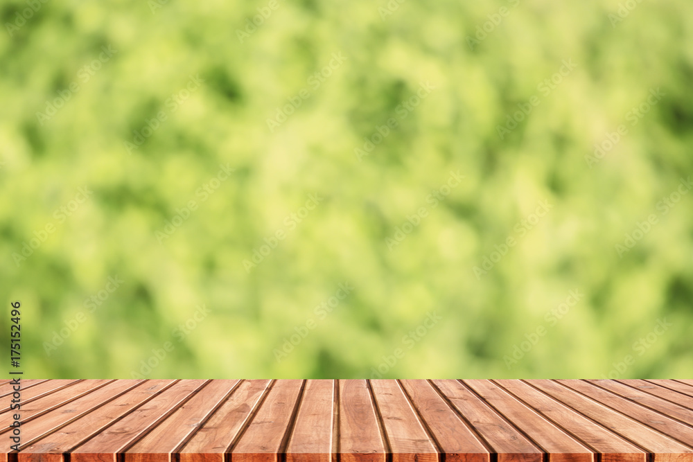 Empty top wooden table blurred green leaves, Green abstract blur background Empty top wooden table blurred green leaves, Green abstract blur background