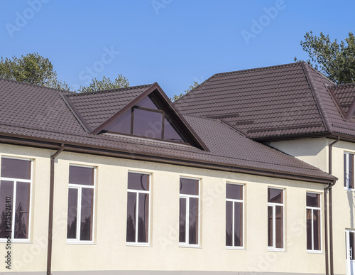 House with plastic windows and roof of corrugated sheet. Roofing of metal profile wavy shape on the house with plastic windows
