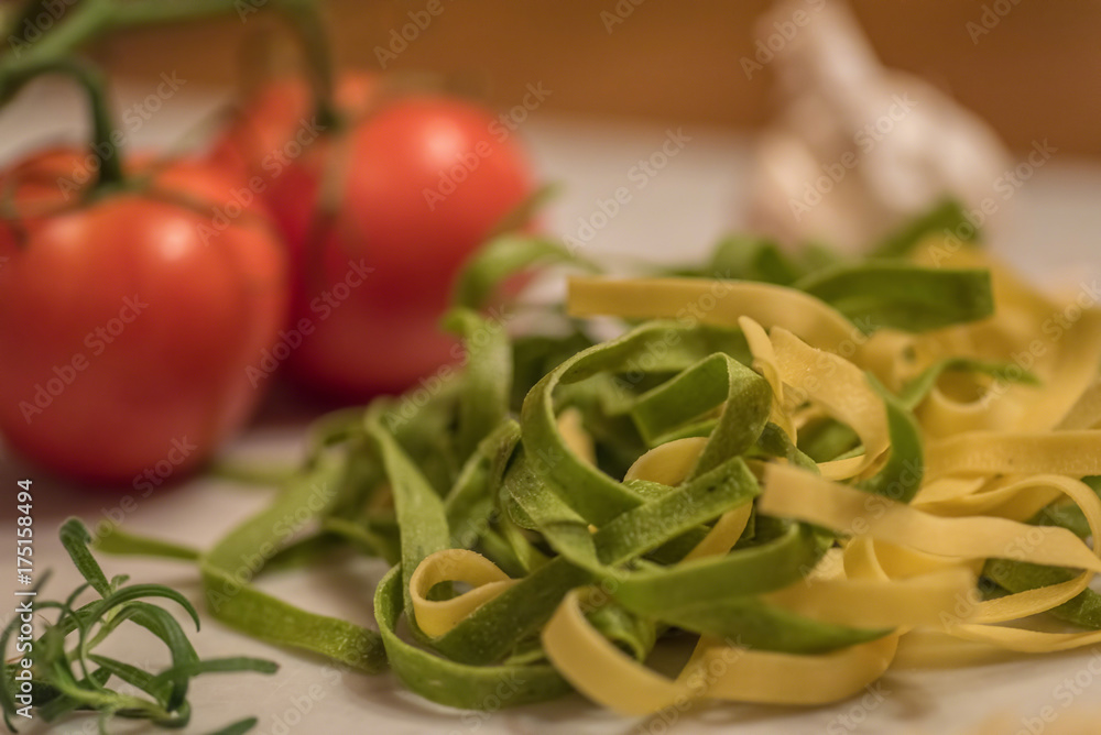 Fresh fettuccine pasta, tomatoes and garlic for meal preparation