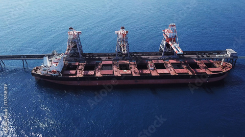 Large bulk carrier ship docking - Unloading coal ship by cranes on the power station dock