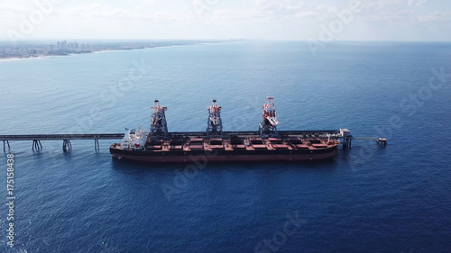 Large bulk carrier ship docking - Unloading coal ship by cranes on the power station dock