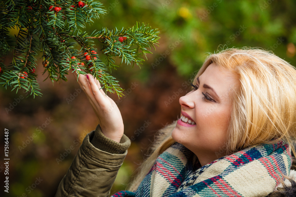 Woman dressed warmly looking at bush Woman dressed warmly looking at bush
