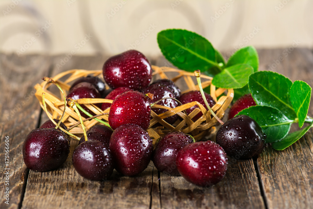 Cherry on a wooden table in a wicker Cherry on a wooden table in a wicker