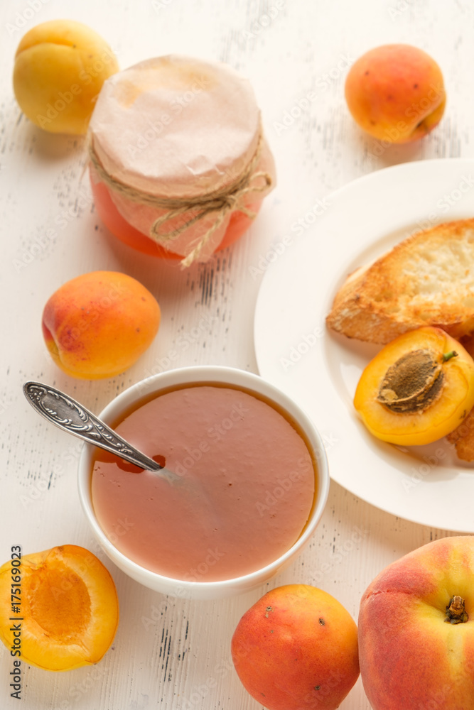homemade jam of ripe peaches on a white wooden background homemade jam of ripe peaches on a white wooden background