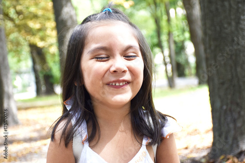 Little latin girl laughing in the park