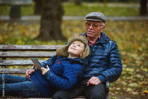 Obraz na płótnie Grandson with grandfather on a walk in the autumn Park . Family values w salonie