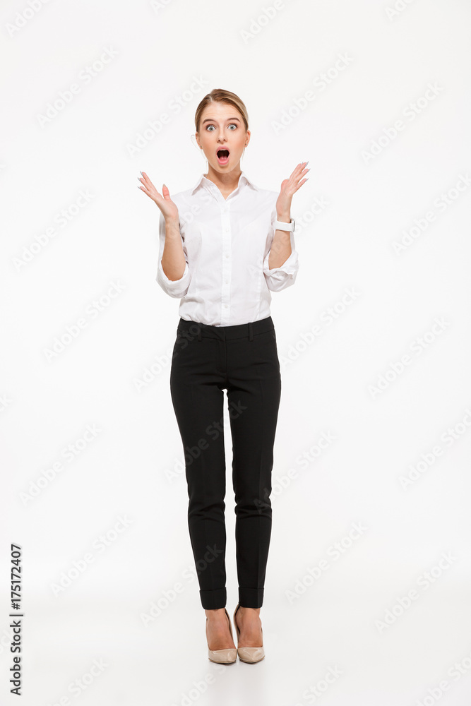 Full length image of shocked blonde business woman holding hands Full length image of shocked blonde business woman holding hands