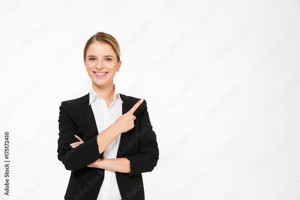 Smiling blonde business woman pointing away and looking at camera Smiling blonde business woman pointing away and looking at camera