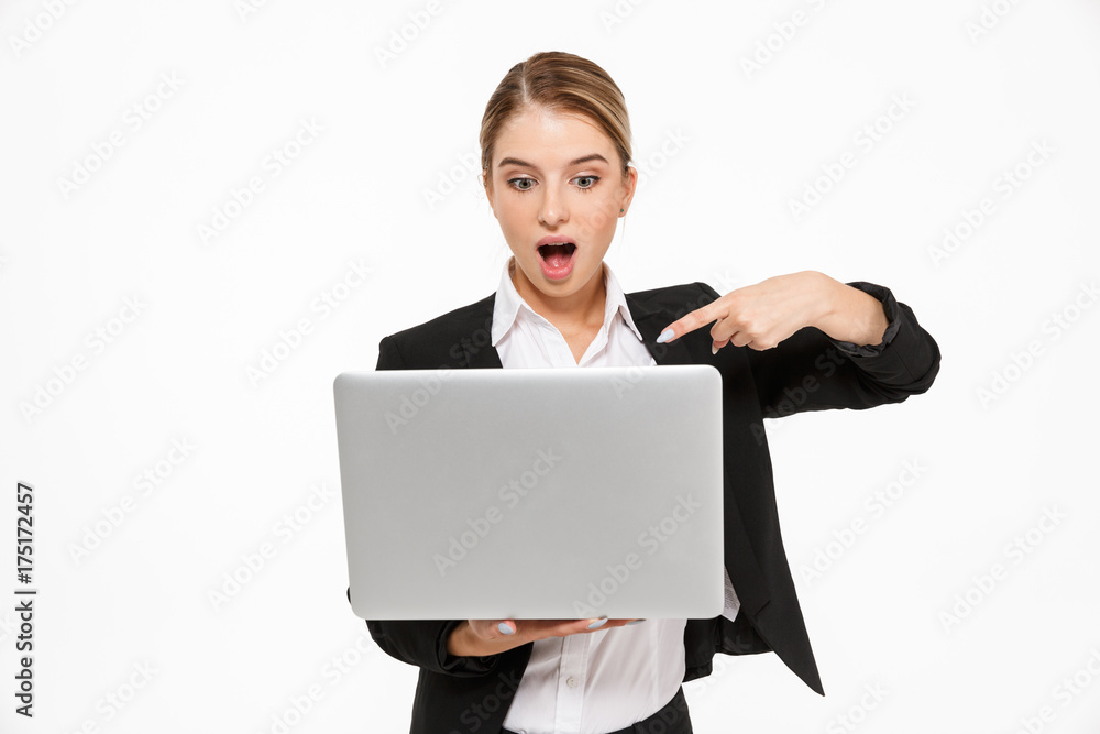 Shocked blonde business woman holding laptop computer Shocked blonde business woman holding laptop computer