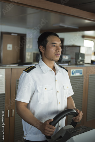 Junior Navigation Officer hand steering on bridge