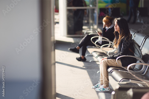 Young woman waiting for plane at airport lounge
