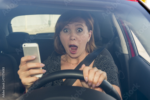 beautiful woman  driving car while texting using mobile phone distracted