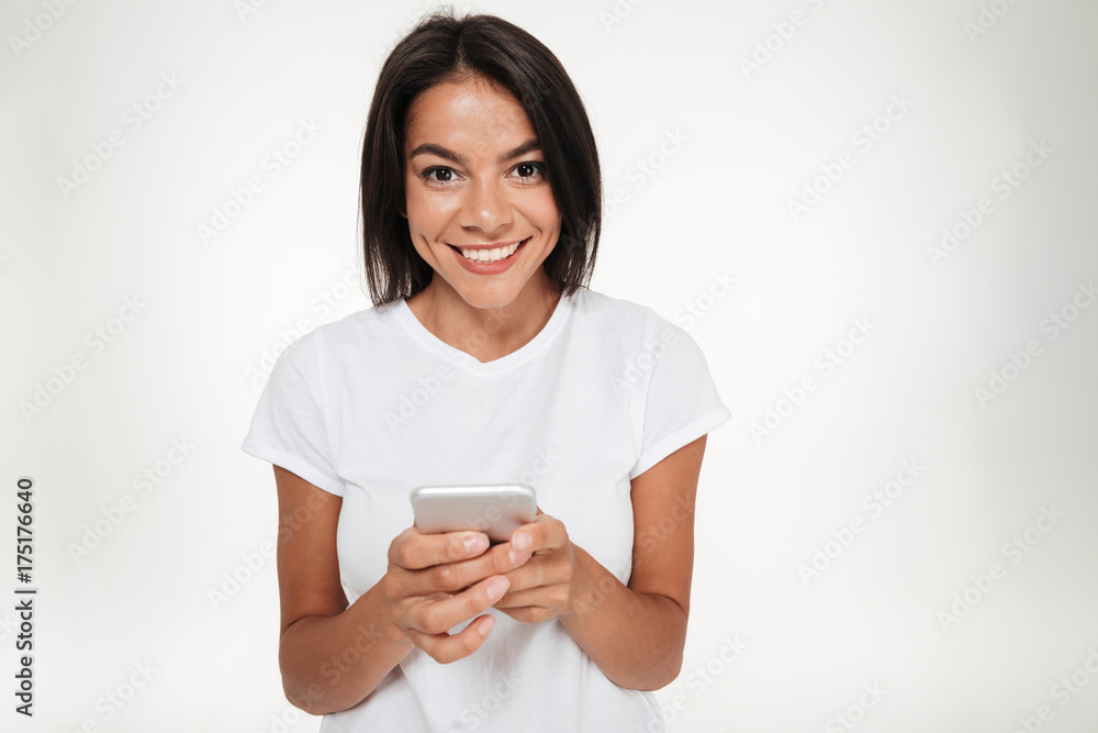 Portrait of a happy brunette woman holding mobile phone Portrait of a happy brunette woman holding mobile phone