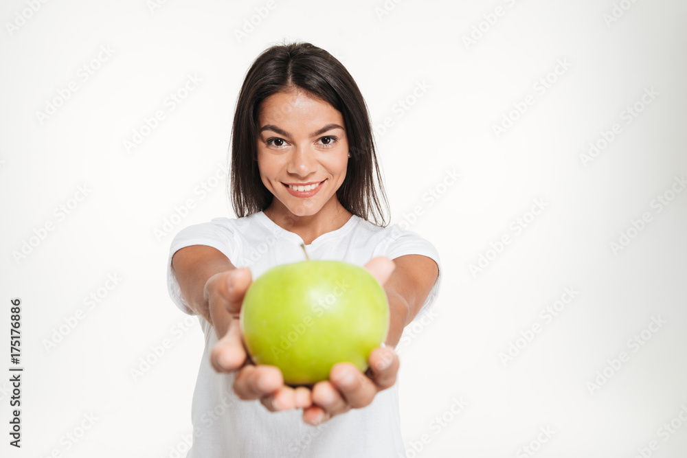 Portrait of a smiling healthy woman showing green apple Portrait of a smiling healthy woman showing green apple