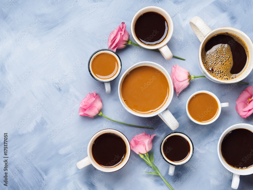 Group of Cups and mugs of coffee and pink flowers on blue background. Flat lay still life Group of Cups and mugs of coffee and pink flowers on blue background. Flat lay still life
