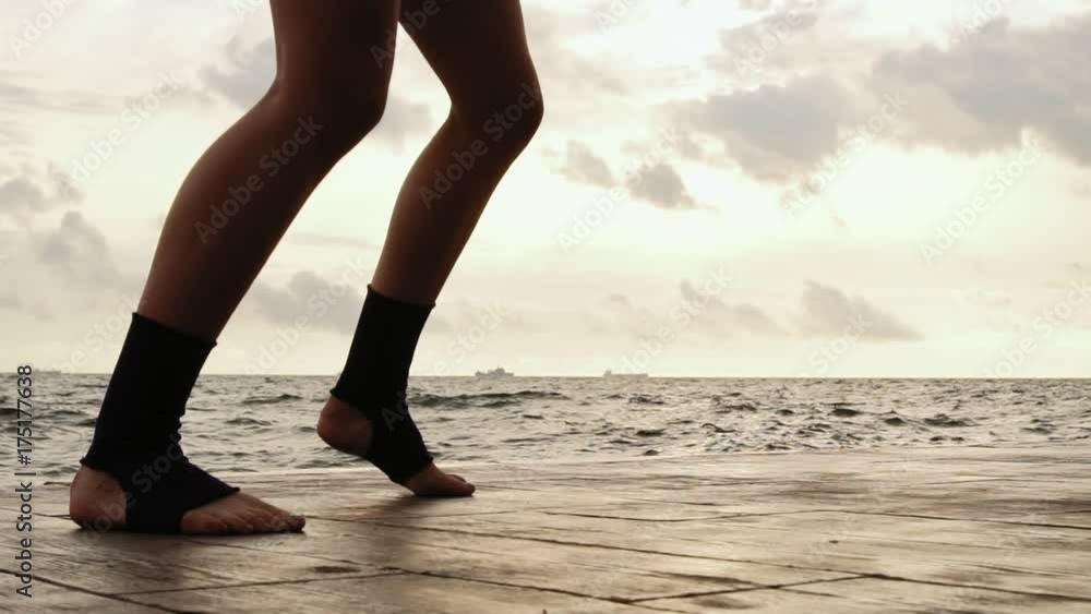 Female boxer's legs moving on during the training. Woman is training by the beach. Closeup on legs. Slowmotion shot Female boxer's legs moving on during the training. Woman is training by the beach. Closeup on legs. Slowmotion shot