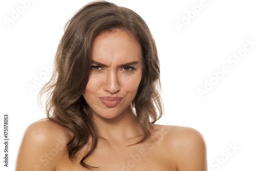 Portrait of beautiful young woman making funny faces on white background